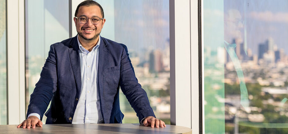 IMAGE: CurveBiosciences founder, Ritish Patnaik, standing at a table with the Dallas skyline behind him.