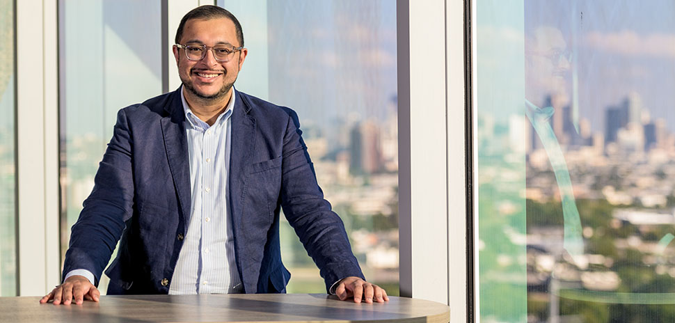 IMAGE: CurveBiosciences founder, Ritish Patnaik, standing at a table with the Dallas skyline behind him.